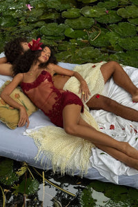 Two people lying on a bed surrounded by water lilies